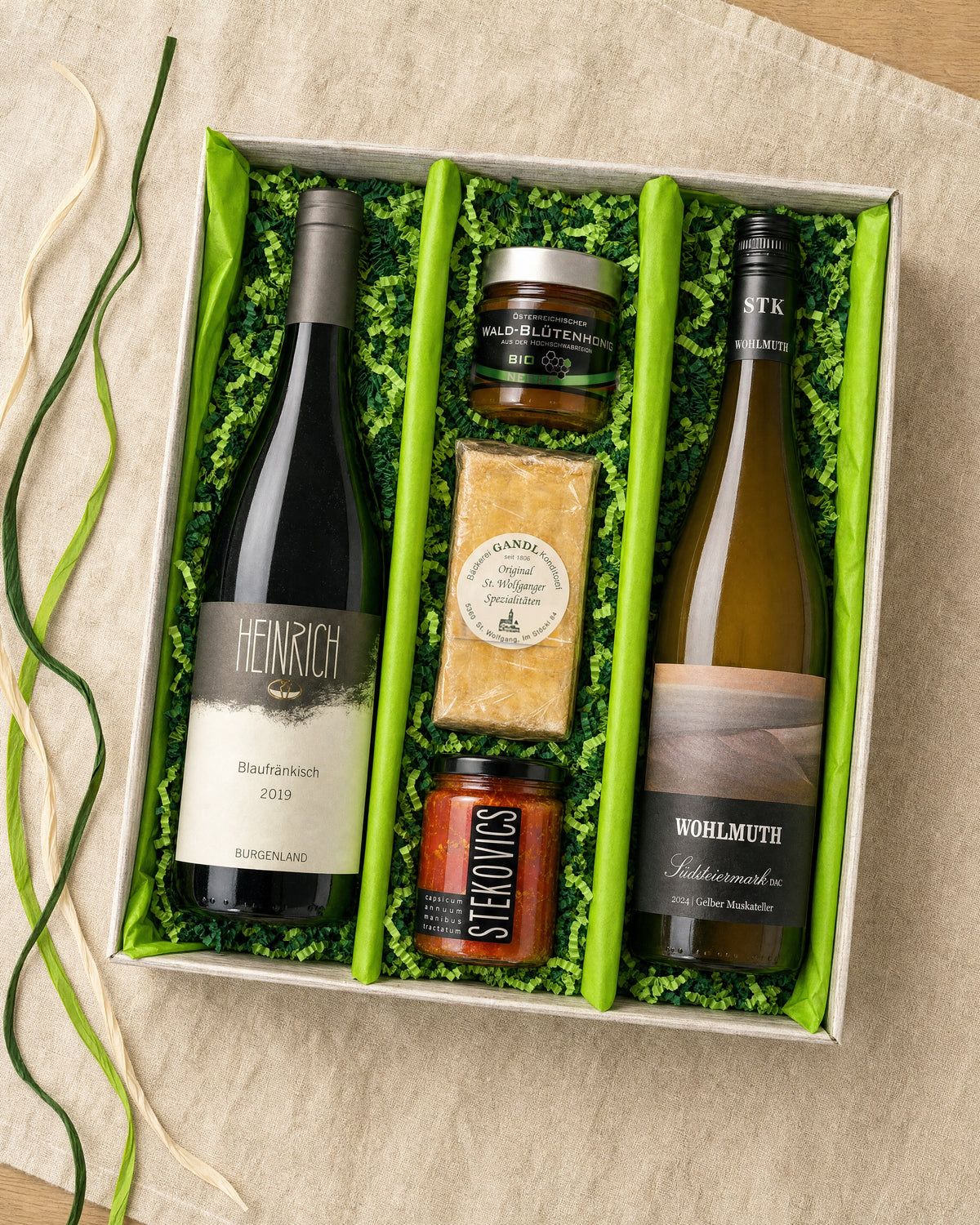 Gourmet Geschenk Spezereien – Geschenkkorb von oben mit Blaufränkisch, Mangalizia Paprika, Nussschnitte, Wald-Blütenhonig und Gelbem Muskateller