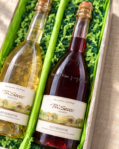 PriSecco Rotfruchtig 750 ml im Geschenkset, Detailaufnahme im Zweierkarton mit hellgrünem Papier und gemischter grüner Papierwolle