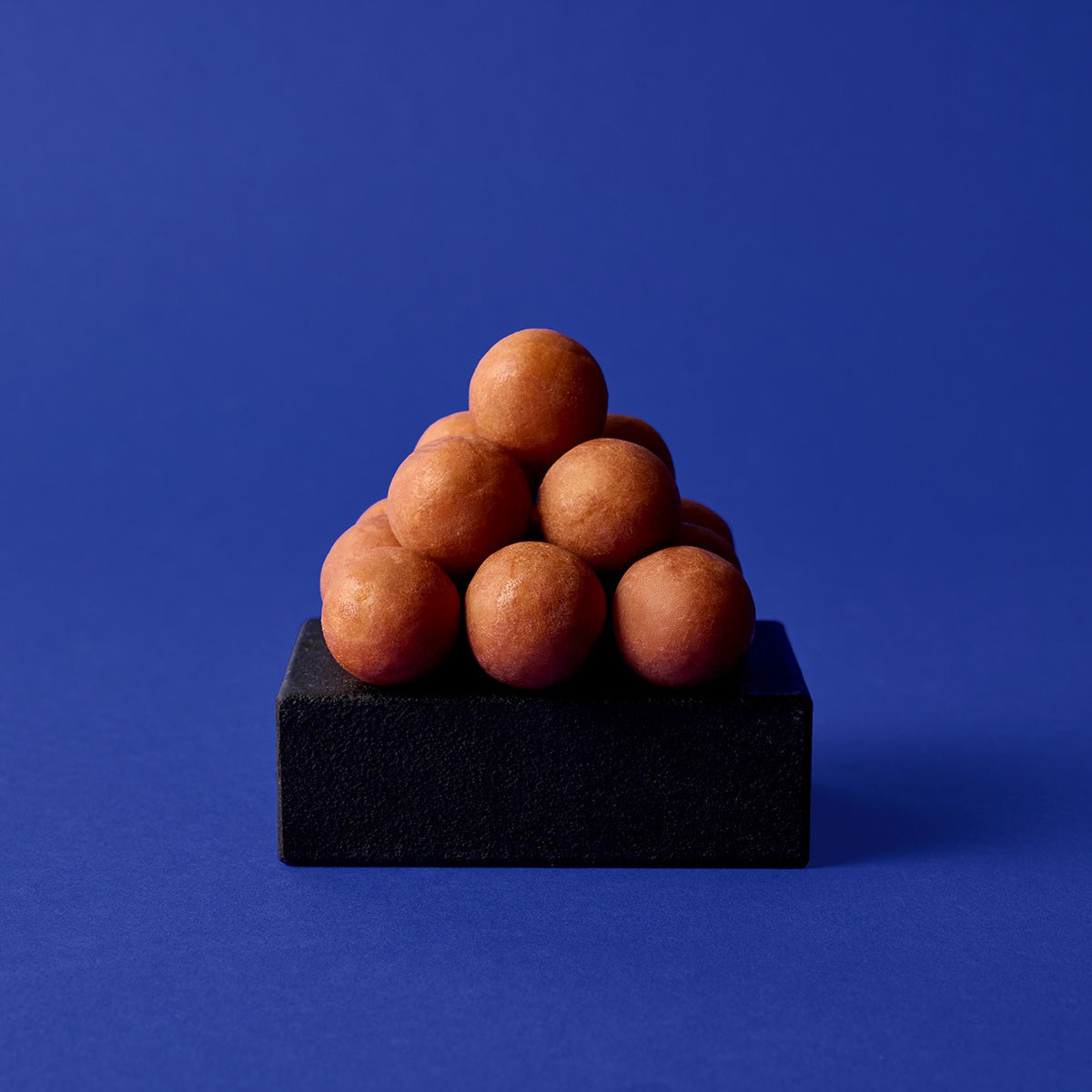 Marzipankartoffeln von Sawade als kleine Pyramide auf dunklem Sockel