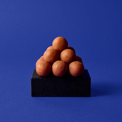Marzipankartoffeln von Sawade als kleine Pyramide auf dunklem Sockel
