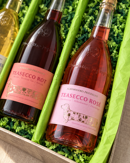 TeaSecco Rosé im TeaSecco Trio Geschenkset – Detailaufnahme mit hellgrünem Papier und gemischtem grünem Sizzlepack