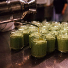 Grünes Pesto wird bei Vitelium in Gläser gefüllt und mit Olivenöl bedeckt